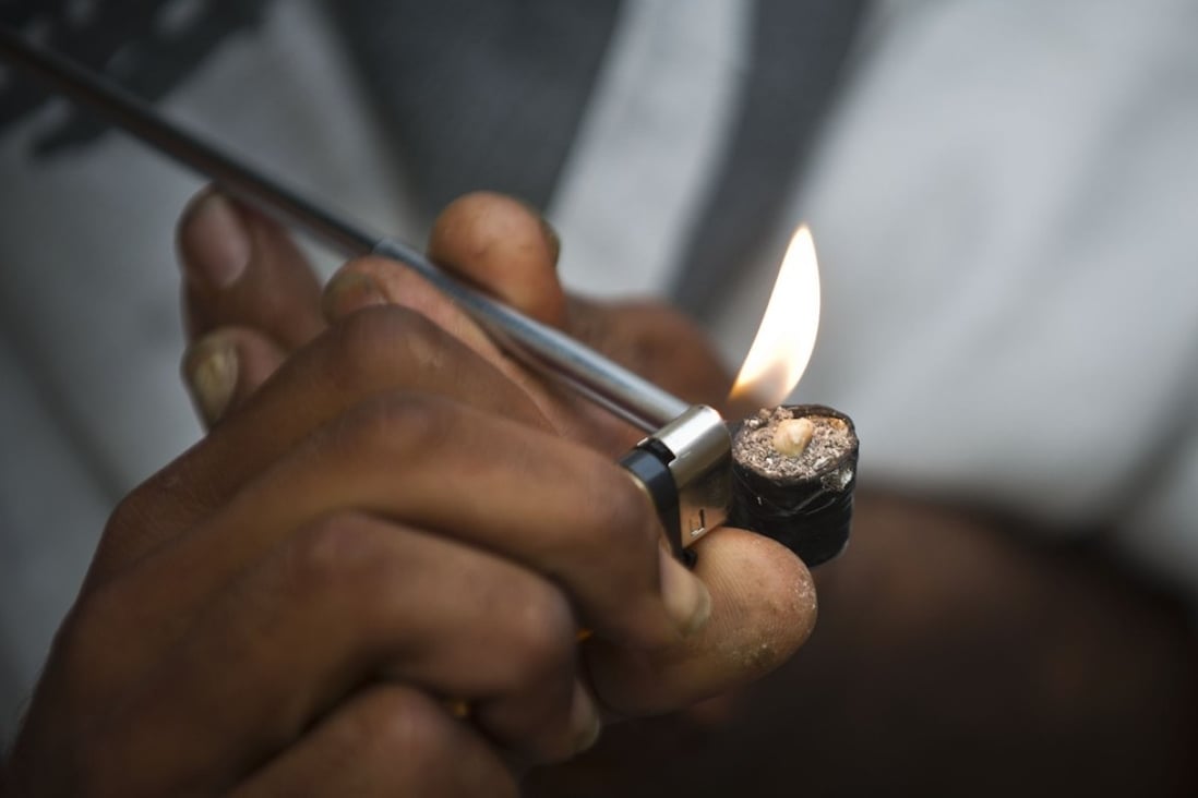 A drug addict lights an improvised pipe on the street in downtown Sao Paulo, Brazil. Claims that a homeless Brazilian woman was ordered to undergo forced sterilisation are sparking accusations of a nightmarish dystopia. Photo: AFP
