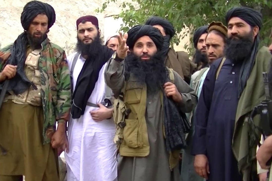 File photo of Mullah Fazlullah (centre) and members of his TTP militant group. Photo: EPA