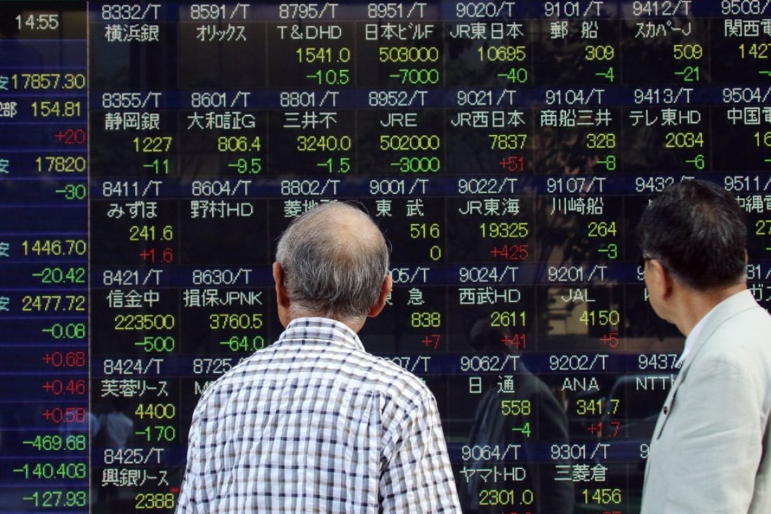 Investors watch a share prices board in Tokyo. Photo: AFP PHOTO