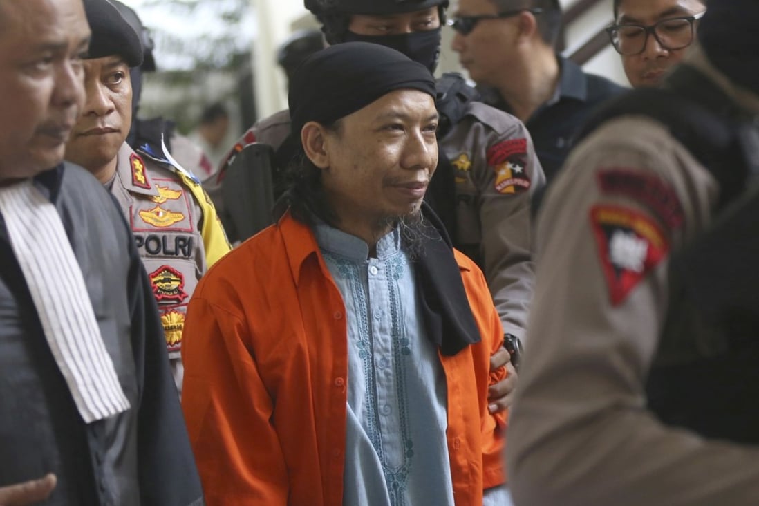 Islamic cleric Aman Abdurrahman is escorted by police upon arrival for his trial at South Jakarta District Court on June 22, 2018. Photo: AP
