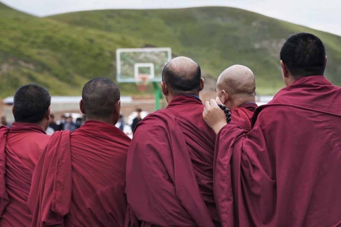 Tibetan monks watch a basketball game in a scene from the documentary Ritoma.