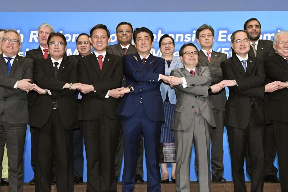 Japanese Prime Minister Shinzo Abe, centre, joins hands with trade ministers from Asian countries for a group photo during the Regional Comprehensive Economic Partnership (RCEP) meeting in Tokyo. Photo: AP