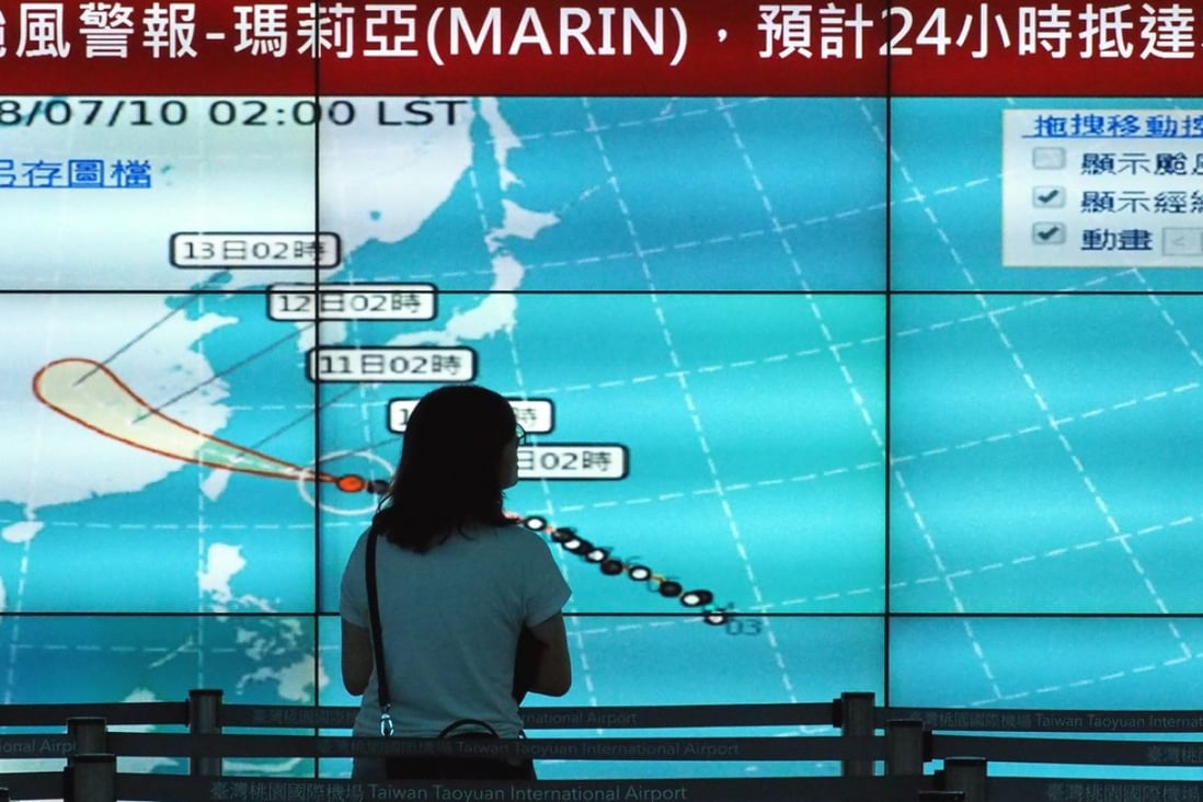 A woman looks at a display with a typhoon chart at Taoyuan International Airport in Taiwan. Super typhoon Maria was heading towards the island on Tuesday morning and as expected to hit the north the hardest. Photo: EPA-EFE