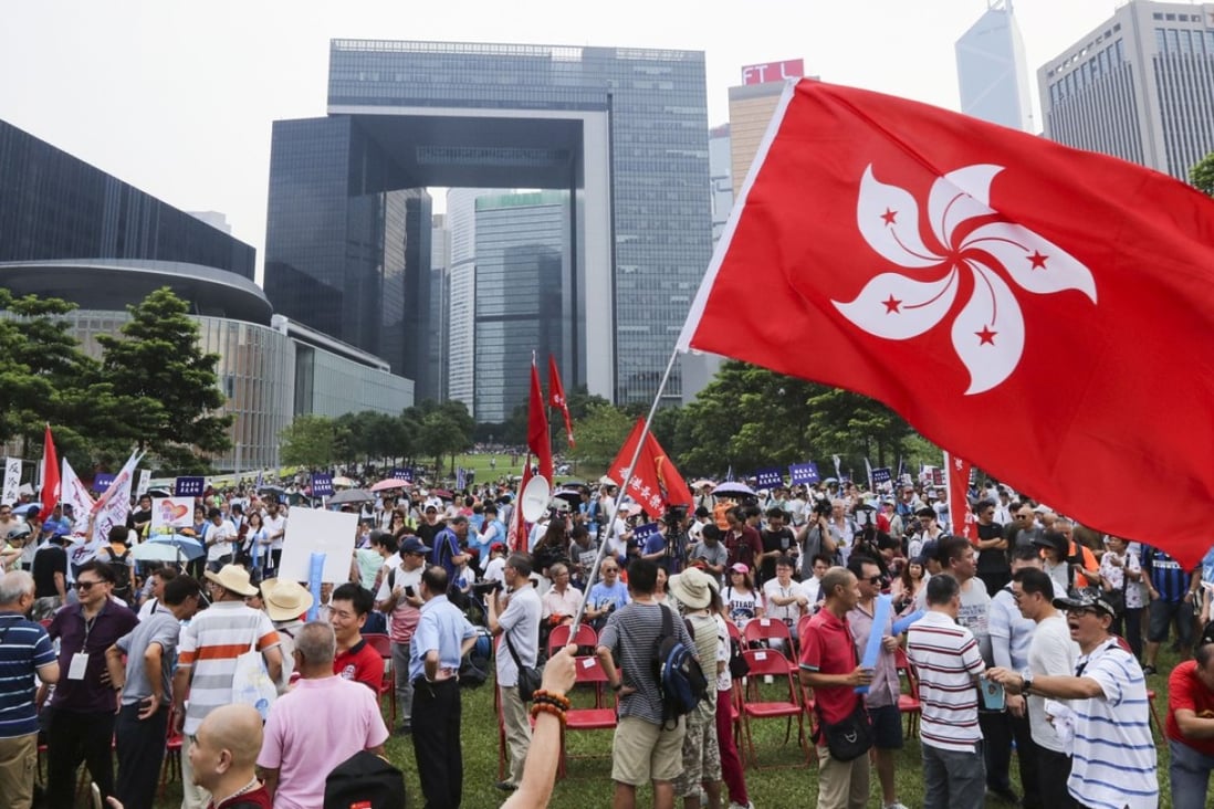 A protester waves a Hong Kong flag at Tamar Park during a rally urging the University of Hong Kong to dismiss law scholar Benny Tai, a co-founder of the Occupy Central civil disobedience movement. Photo: Felix Wong