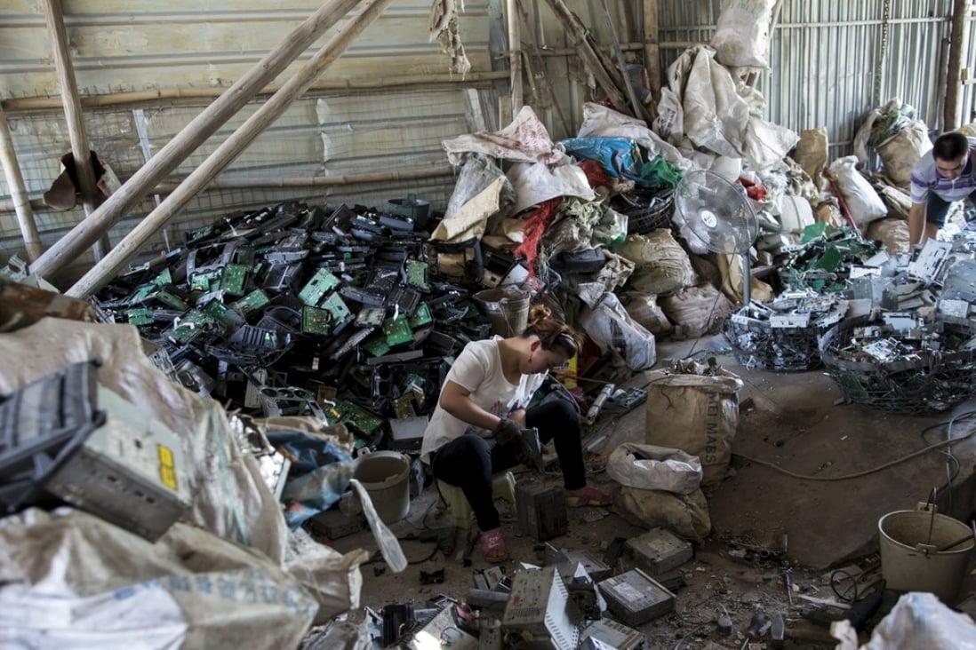A worker recycles CD players at a workshop in Guiyu, a town notorious for its pollution problems. Photo: Reuters