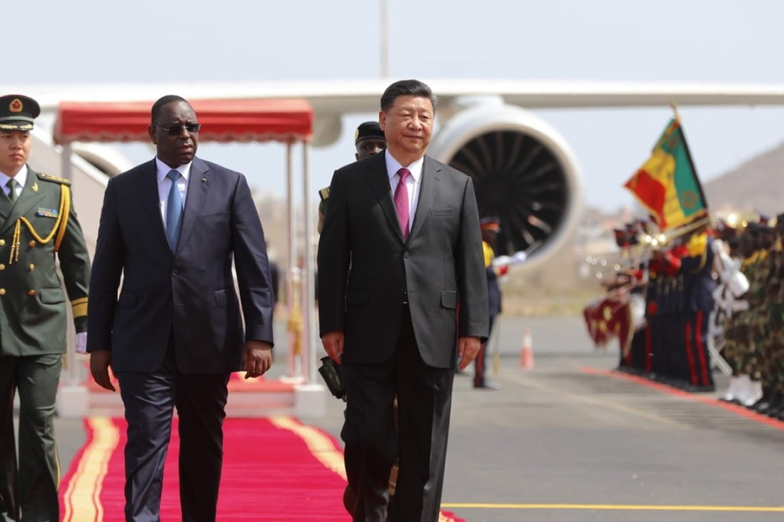 Senegal’s President Macky Sall walks with Chinese President Xi Jinping after Xi’s arrival for a two-day visit. Photo: AFP