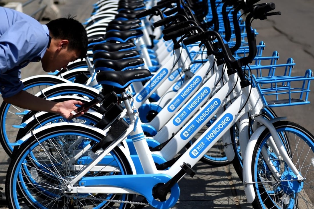 A local resident uses his smartphone to scan a QR code on a bicycle of bike-sharing service provider Hellobike on a street in Luoyang City, in central China’s Henan province. Photo: Imaginechina