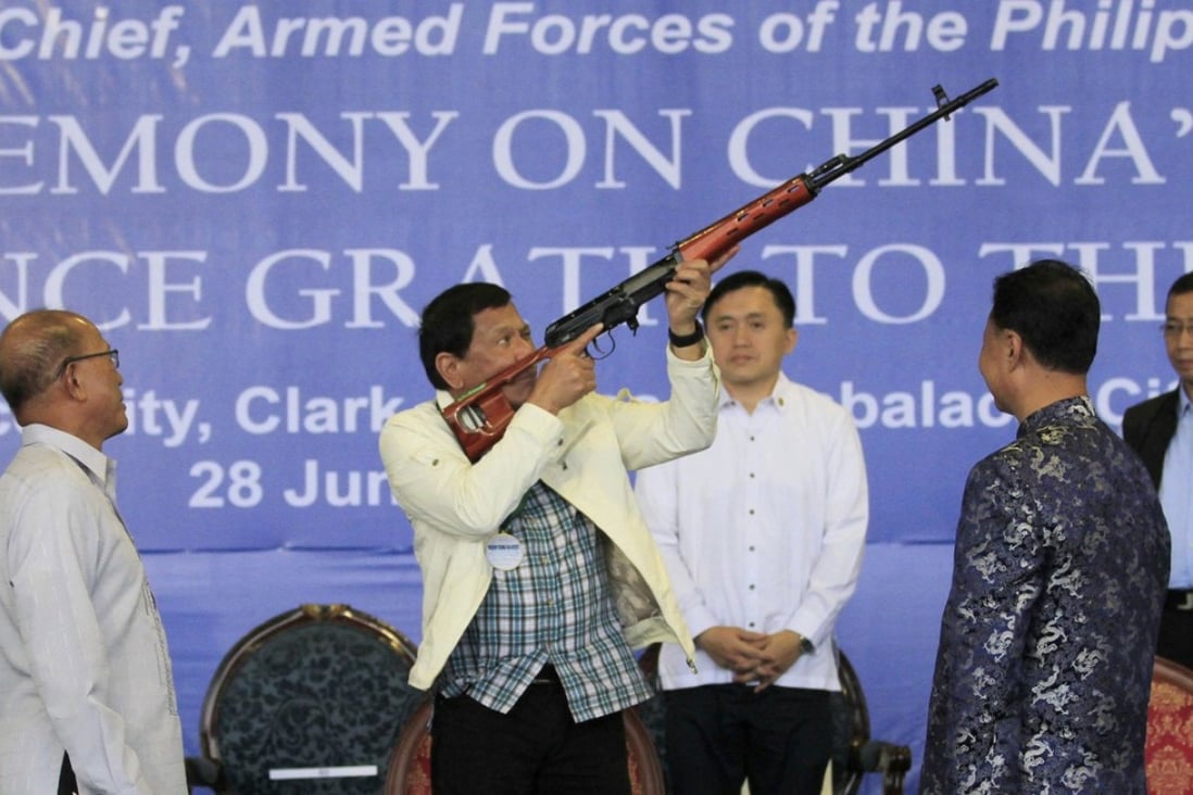 Philippine President Rodrigo Duterte checks a Chinese-made rifle during the ceremonial handover of military weapons from China to the Philippines inm 2017. File photo: EPA