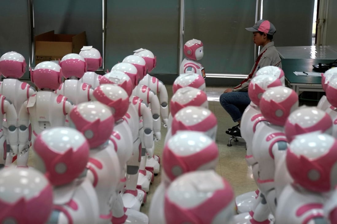 A worker faces an iPal robot, created by AvatarMind, at an assembly plant in Suzhou, Jiangsu province, China, on July 4. Designed to offer education, care and companionship to children and the elderly, the 3.5-feet tall humanoid robots come in two genders and can tell stories, take photos and deliver educational or promotional content. Photo: Reuters