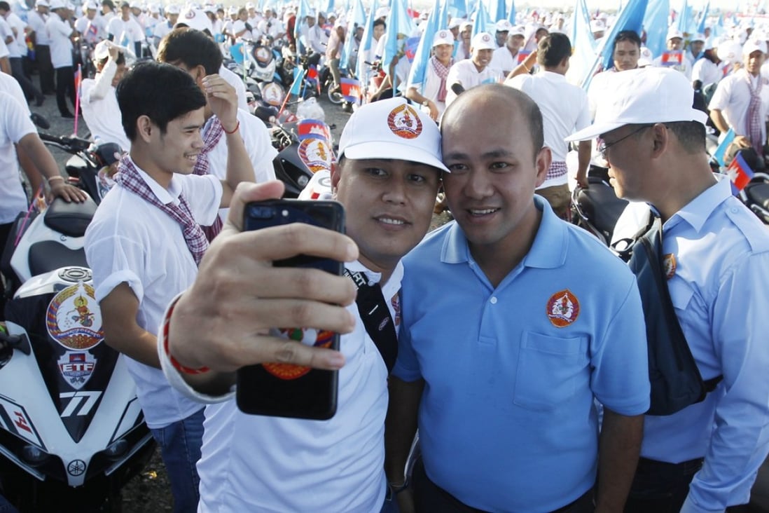 Like father, like son: Cambodian Prime Minister Hun Sen's son Hun Manet with a supporter of the Cambodian People's Party. Photo: EPA