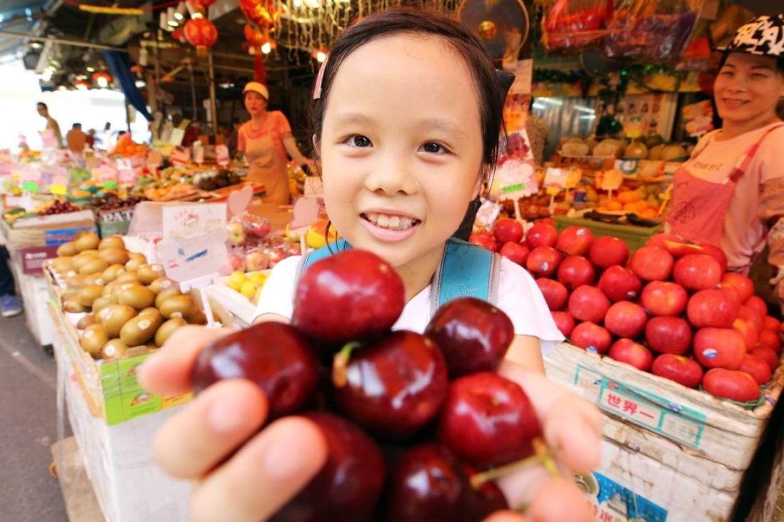 Chloe Lam holds a bunch of cherries she bought at the Yau Ma Tei Fruit Market. Photo: Dickson Lee