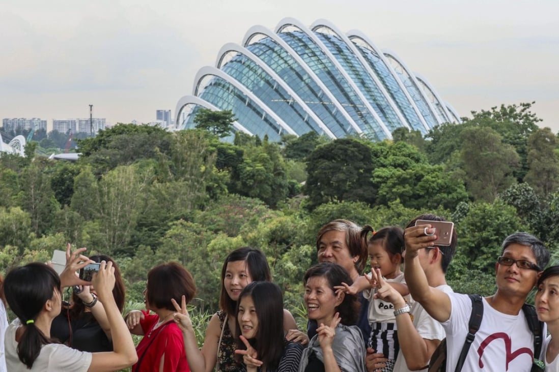 Tourists taking pictures and selfies of the Supertree Groves at Gardens by the Bay, a nature park in Singapore. Photo: SCMP