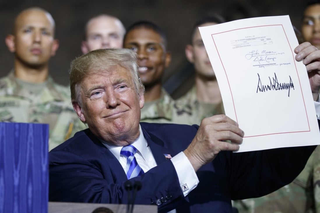 President Donald Trump signs the new US defence act on Monday. Photo: AP