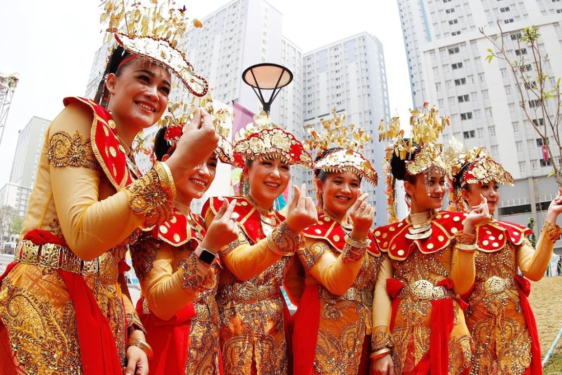 Etiquette team members in Indonesian folk costume at the Asian Games Village. Photo: Xinhua
