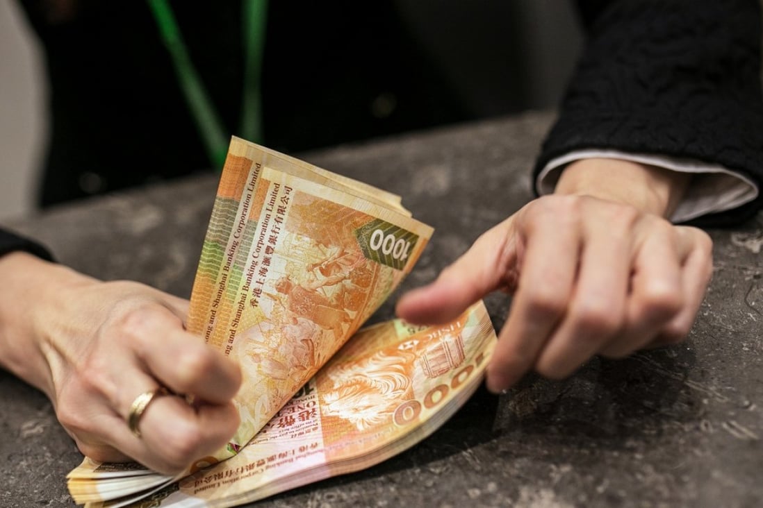 An employee counts HK$1,000 banknotes inside the Hang Seng Bank. Photo: Bloomberg