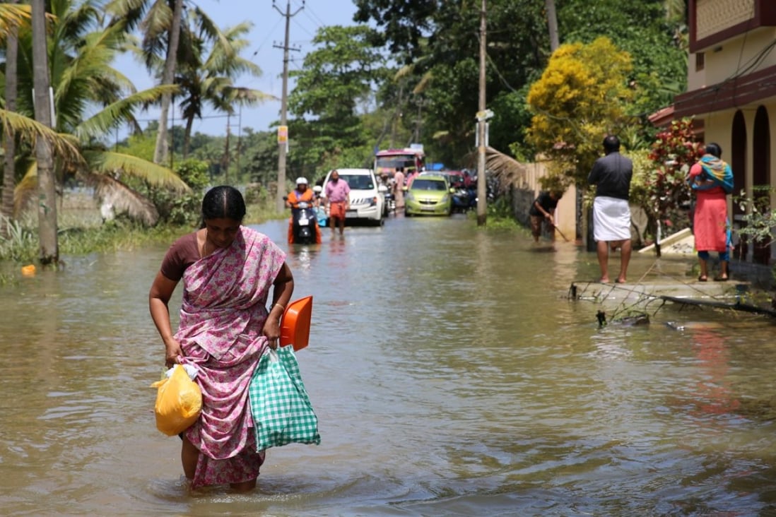 People wade through floodwater in Kerala. Photo: Xinhua