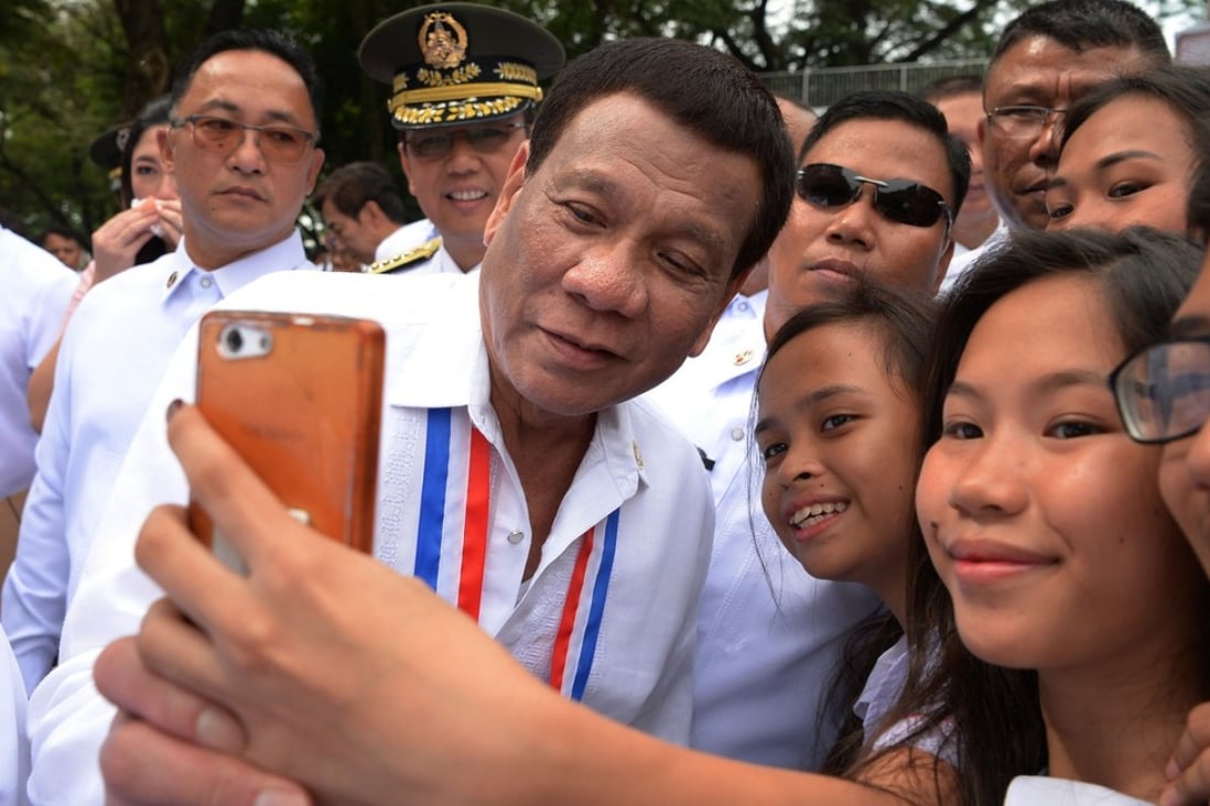 Philippines' President Rodrigo Duterte poses for a selfie with students this week in Manila. Photo: AFP
