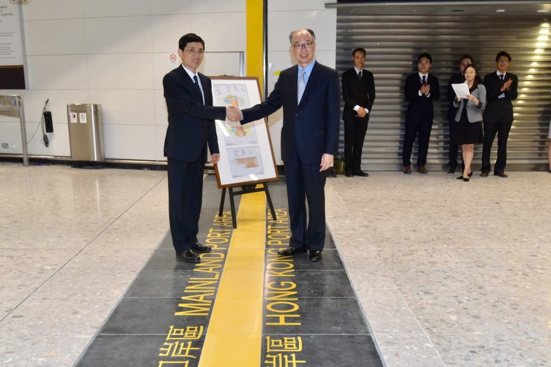 Hong Kong transport secretary Frank Chan (right) hands over the plans for the mainland port area to Yang Xiuyou (left), deputy secretary general of the Shenzhen Municipal People's Government. Photo: Handout