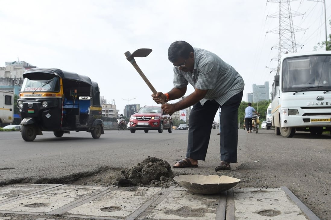 Indian businessman Dadarao Bilhore filling a pothole on the Western Express highway in Mumbai. Photo: AFP
