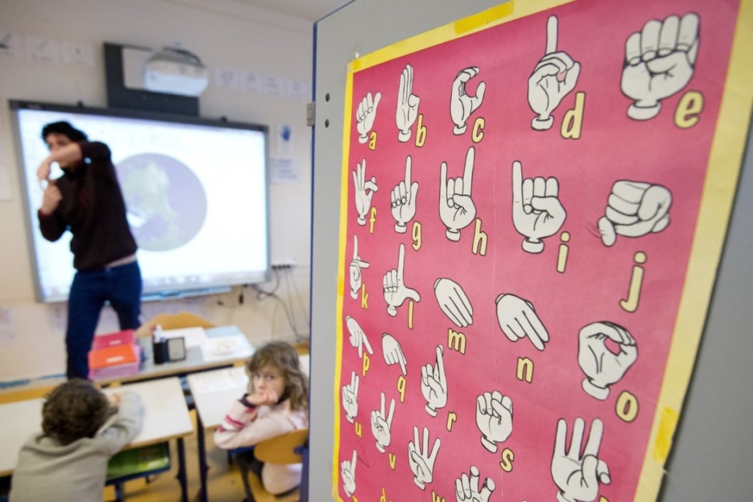 A teacher uses sign language to communicate with hearing-impaired pupils at a school in France. Picture: AFP
