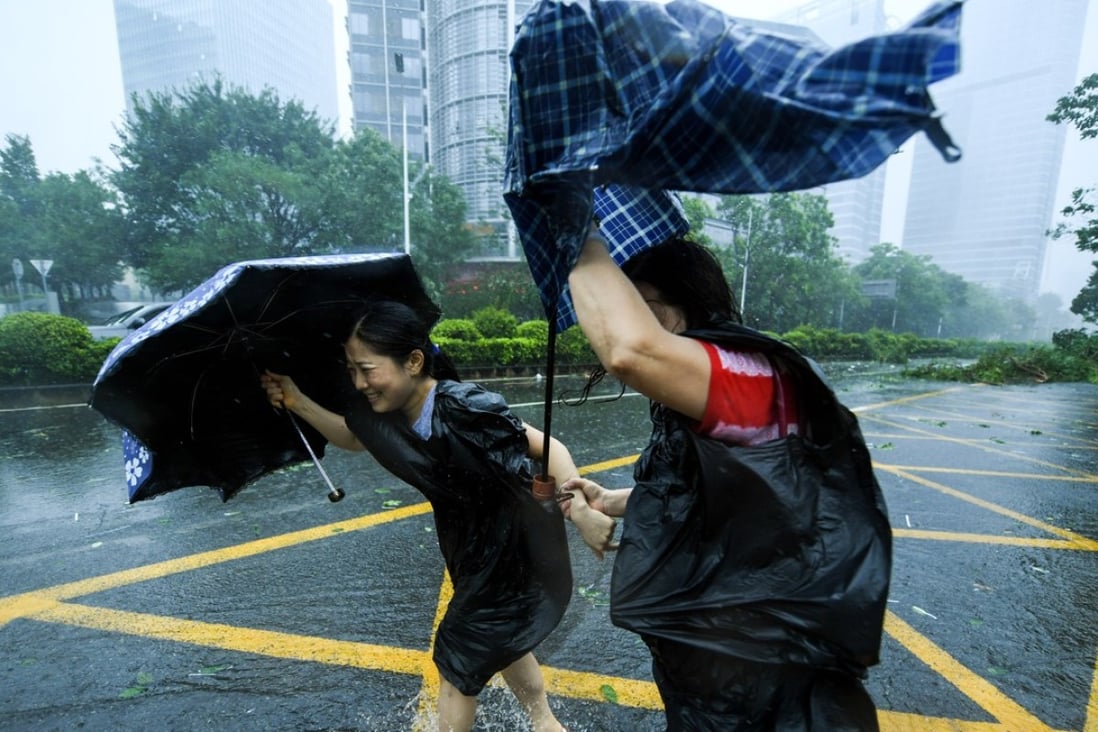Two residents brave the wind in Shenzhen’s Nanshan district on Sunday. Photo: Xinhua