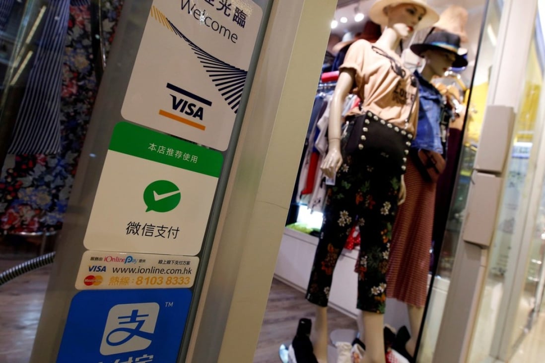 The Hong Kong version of the WeChat Pay mobile payment app, represented by the green tick sign, will soon be available for use to pay for purchases at mainland Chinese merchants. Photo: Reuters