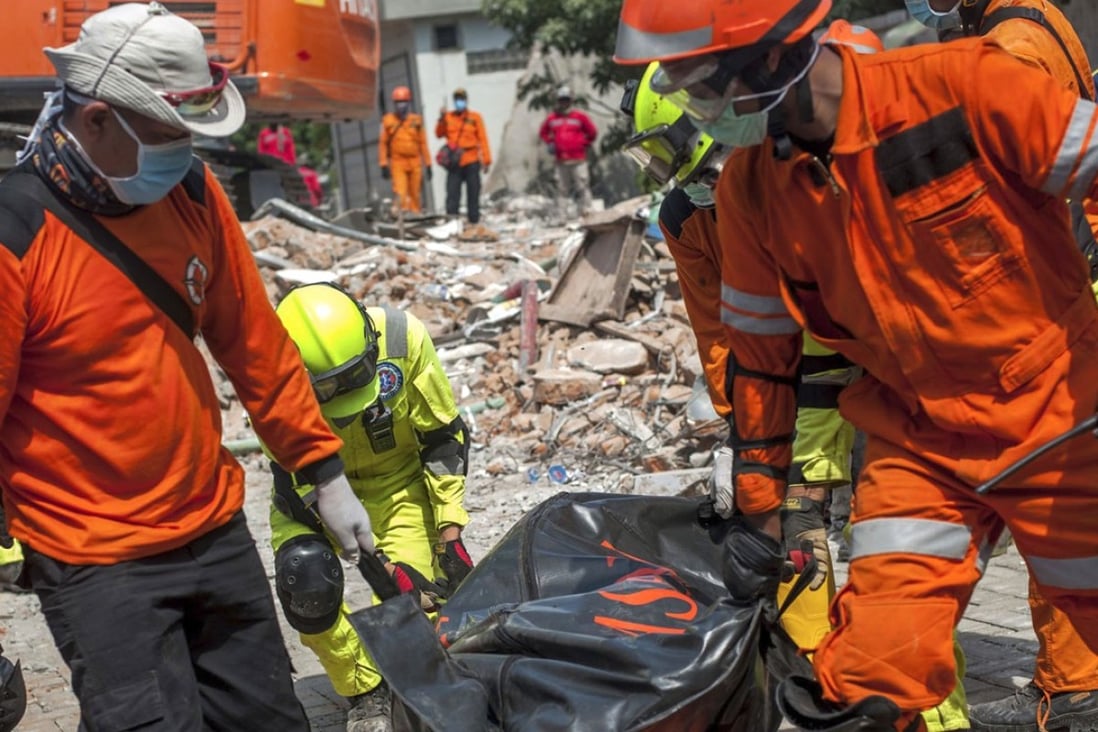 Rescuers recover the body of an earthquake victim from the ruins of the collapsed Roa Roa hotel in Palu. Photo: AP