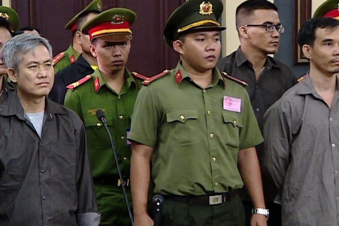 Luu Van Vinh, left, and other activists who were charged of subversion, in court Friday. Photo: AFP
