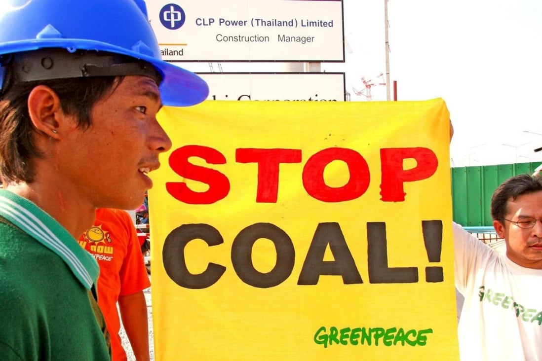 A Thai worker walks past a Greenpeace activist at the BLCP coal power plant in Rayong.