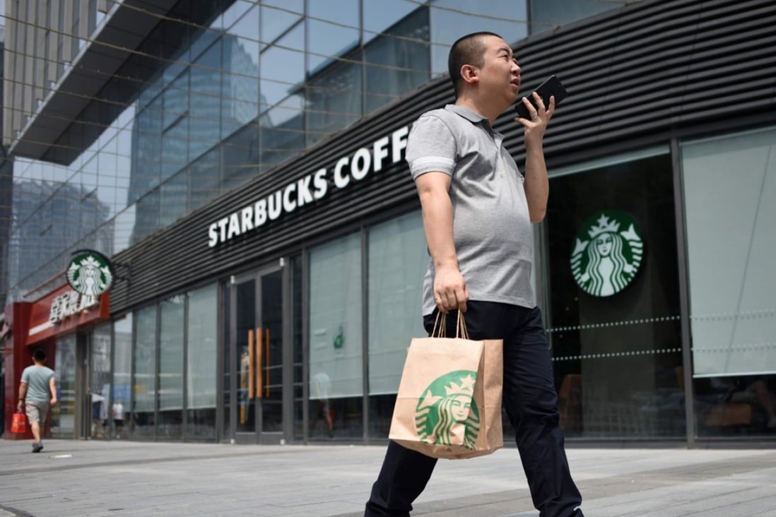 A man walks past a Starbucks coffee shop in Beijing on August 2, 2018. Starbucks on August 2 announced a partnership with e-commerce giant Alibaba that will give the US coffee giant greater access to China's growing food-delivery market as it faces increased competition from local firms. Photo: AFP