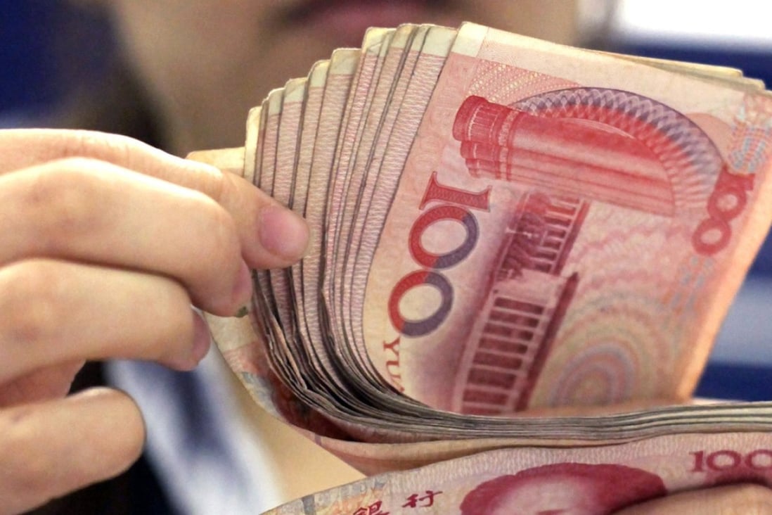 A bank clerk counts a stack of 100 yuan notes in Shanghai. Photo: AP