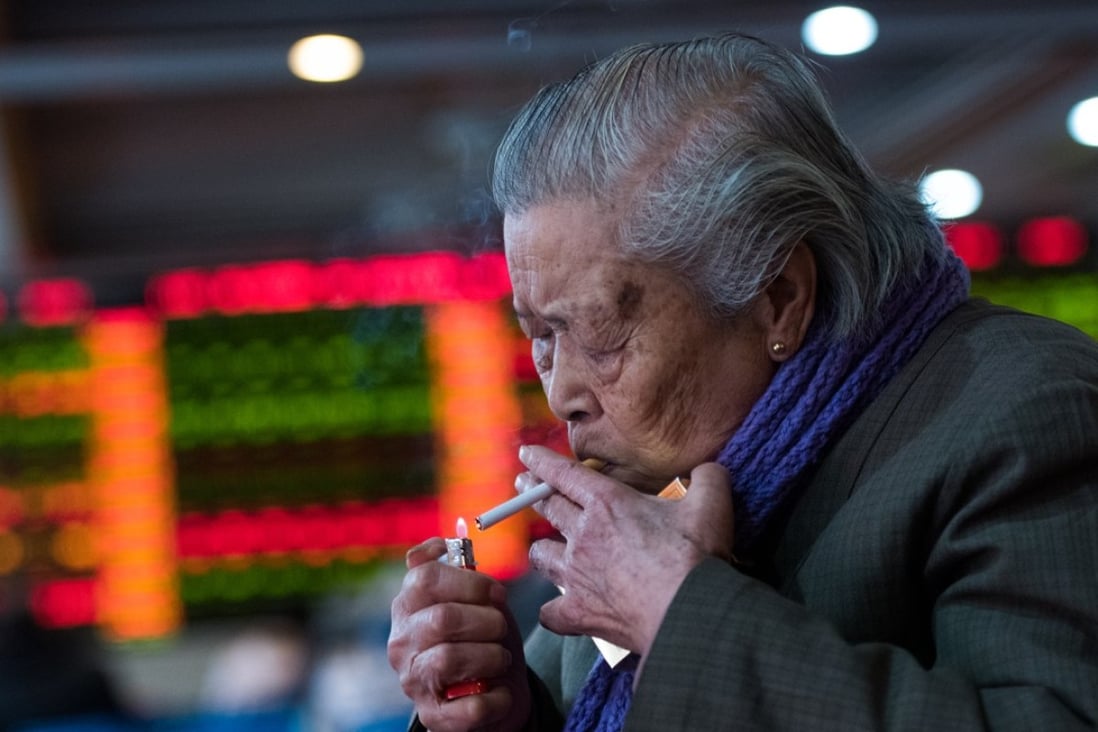 An investor lighting up a cigarette in front of a stock information at a trading hall of a securities firm in Shanghai on January 28, 2014. Photo: Agence France-Presse