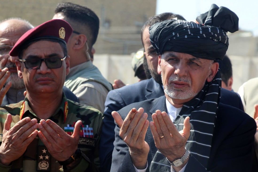 Afghan President Ashraf Ghani (right) visits the grave of General Abdul Razzaq Dawood, an Afghan police commander who was killed in a shootout in Kandahar, Afghanistan, on October 23. Photo: EPA