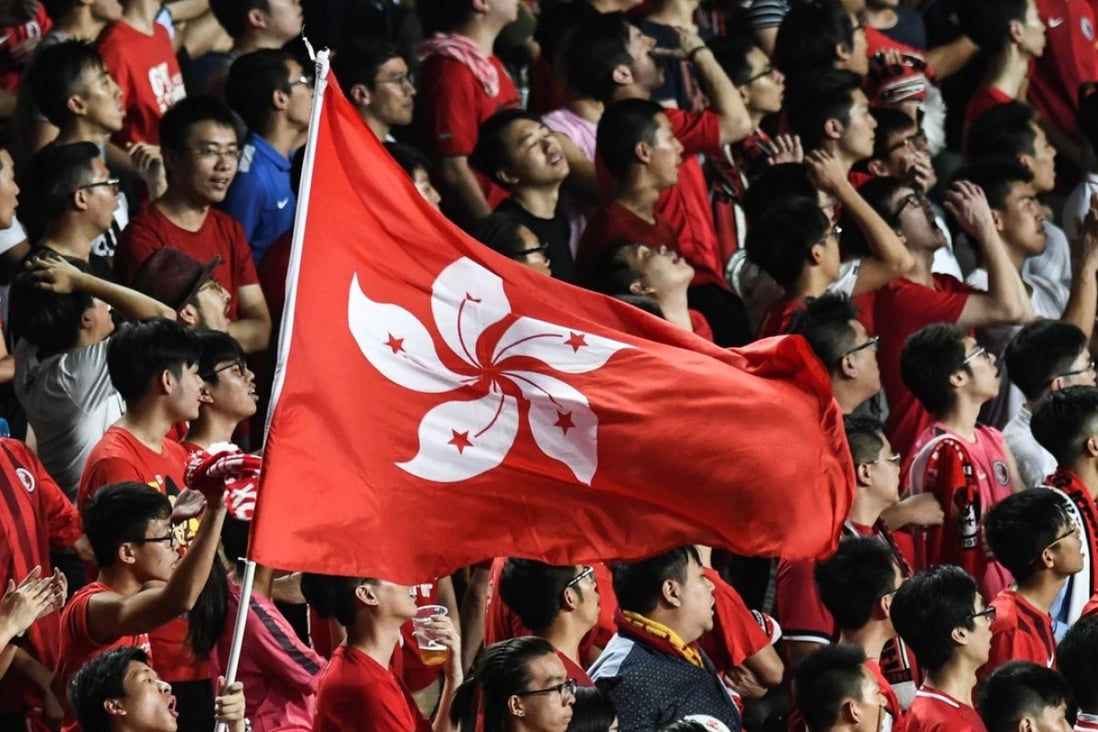 Local football fans hold up the Hong Kong flag during a match against Malaysia in Hong Kong. A new law that punishes disrespect for China's national anthem with up to three years' imprisonment may also apply to Hong Kong and Macau, state media reported. Photo: Anthony Wallace