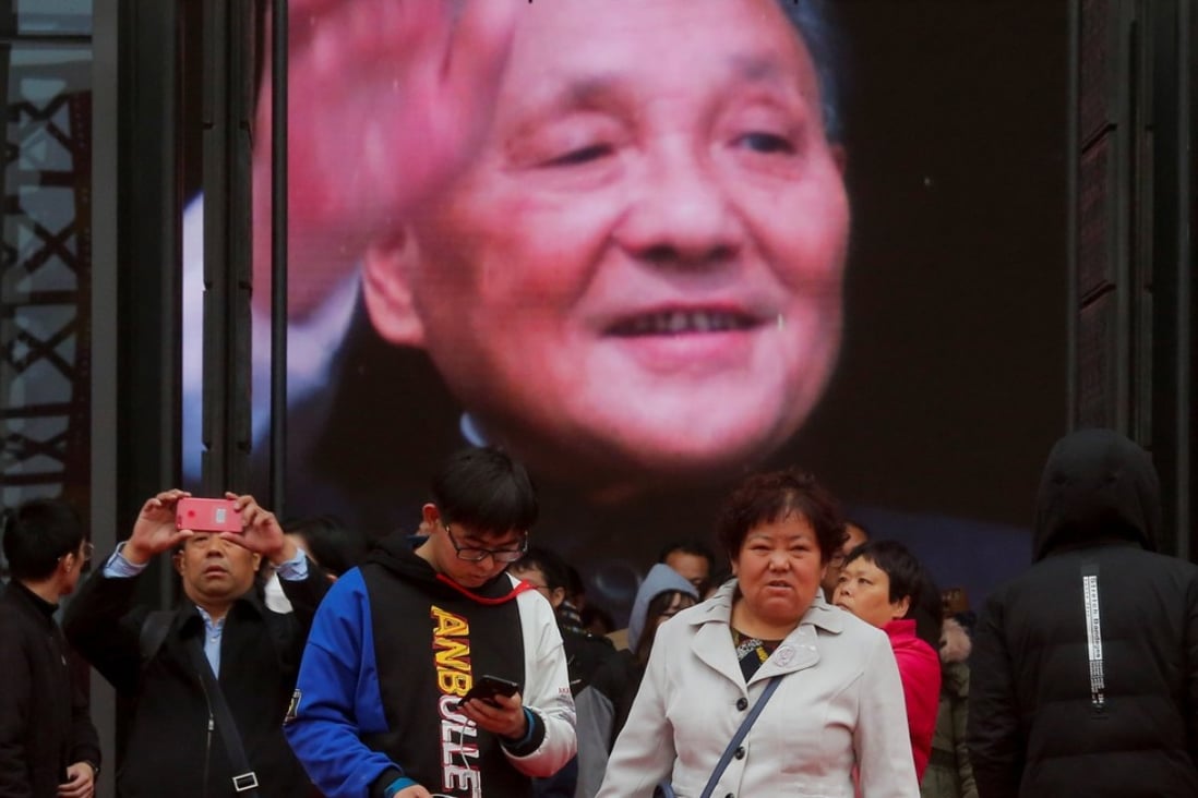 Visitors stand in front of a screen showing former Chinese leader Deng Xiaoping at an exhibition marking the 40th anniversary of China's reform and opening up at the National Museum of China in Beijing, China November 14, 2018. REUTERS/Thomas Peter