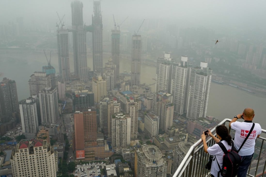 (181115) -- BEIJING, Nov. 15, 2018 (Xinhua) -- Participants stand on the roof of a skyscraper as they take photos of high-rise buildings in Chongqing, southwest China, June 18, 2018. According to a statement issued by the National Bureau of Statistics (NBS), house prices in major Chinese cities remained stable in October as local governments continued tight property regulations. On a month-on-month basis, new house prices in China's four first-tier cities - Beijing, Shanghai, Shenzhen and Guangzhou - were flat with the previous month. New house prices in second-tier cities increased slower than the previous month, while those of third-tier cities saw a faster growth rate in October. (Xinhua/Liu Chan)(clq)