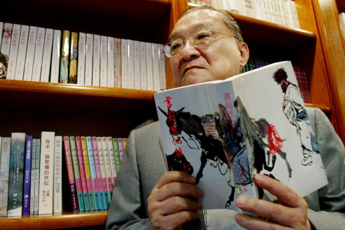 Novelist Louis Cha, who wrote under the name Jin Yong, holds his book "Book and Sword, Gratitude and Revenge" at his office in Hong Kong in 2002. Photo: Reuters