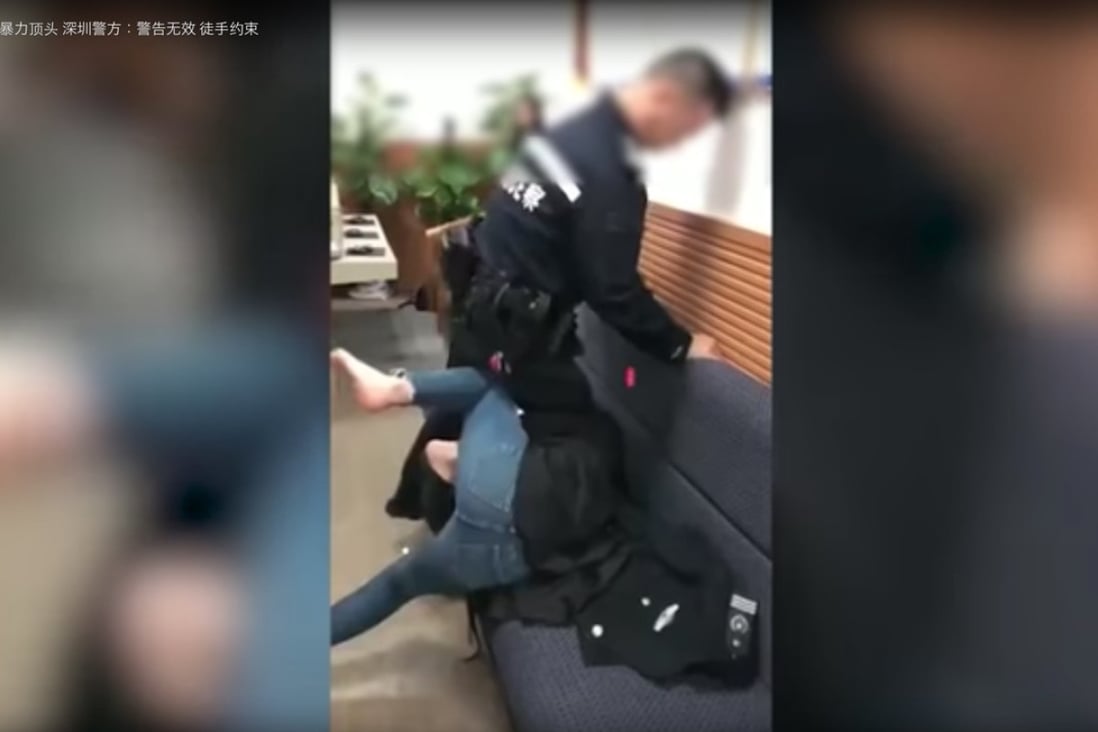 A still from the video showing a Shenzhen policeman pinning down a woman by the neck with his knee. Photo: YouTube