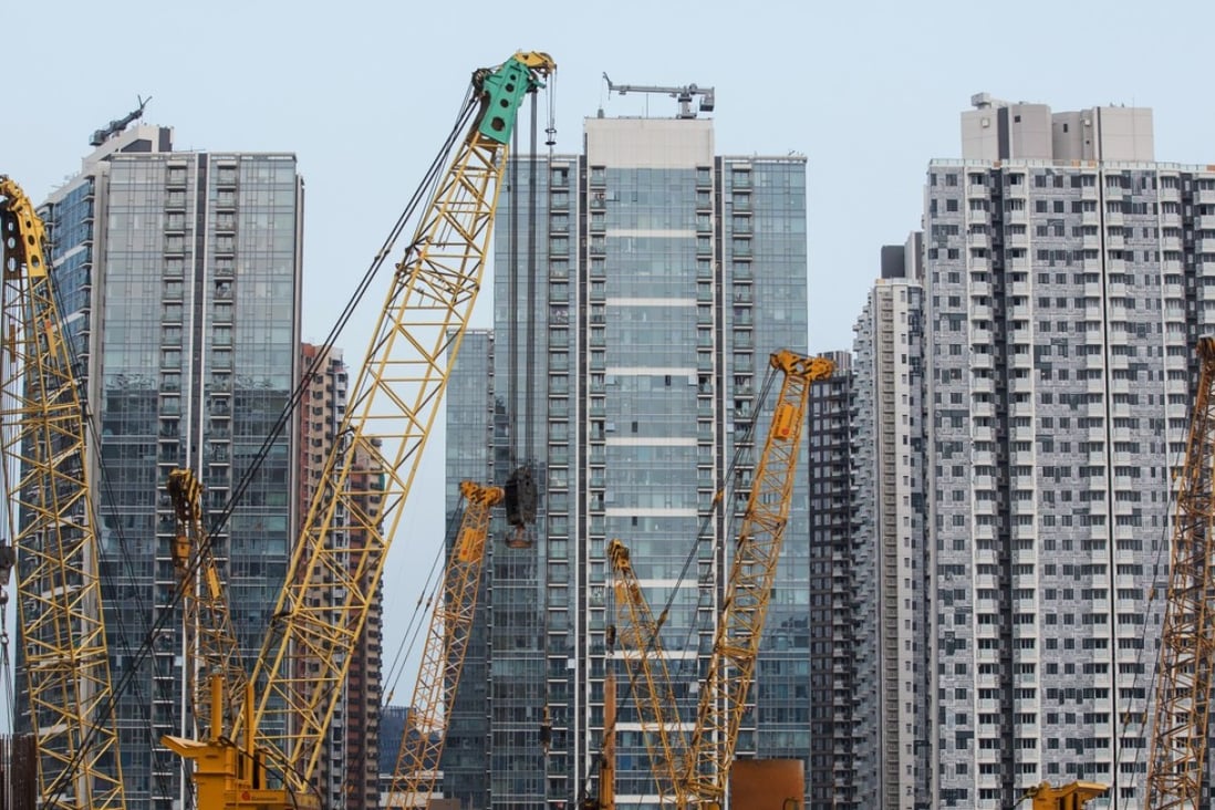 Cranes at a construction site at the former Kai Tak airport area in front of residential buildings in Hong Kong, on Saturday, July 21, 2018. Photo: Paul Yeung/Bloomberg