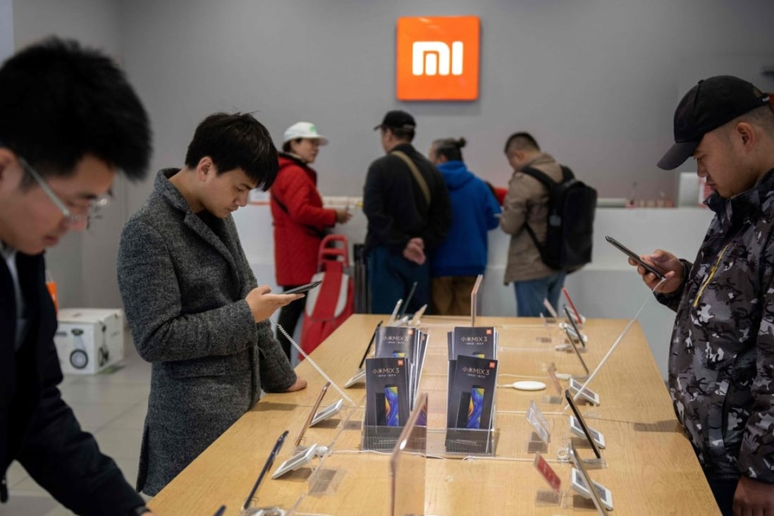 Customers look at mobile phones in a Xiaomi shop in Beijing on November 7, 2018. Photo: AFP