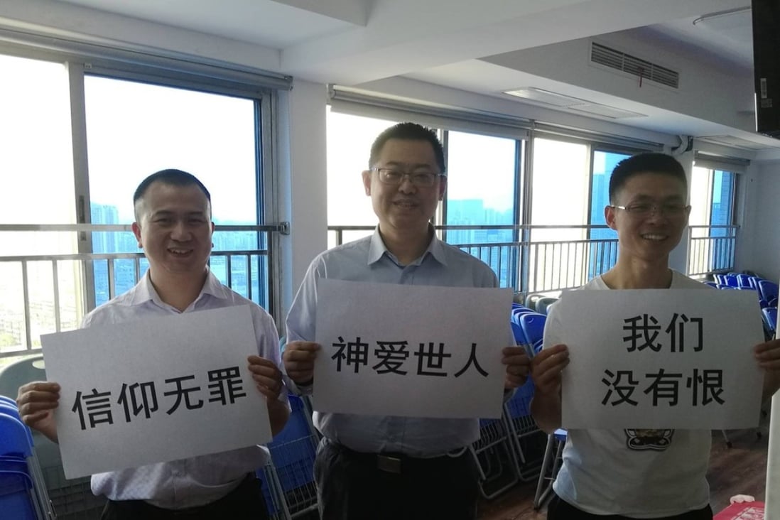 Early Rain Covenant Church pastor Wang Yi (centre) and fellow church members with signs which read: “Faith should not be criminalised”, “God loves all people in the world” and “We have no hatred”. Photo: Facebook