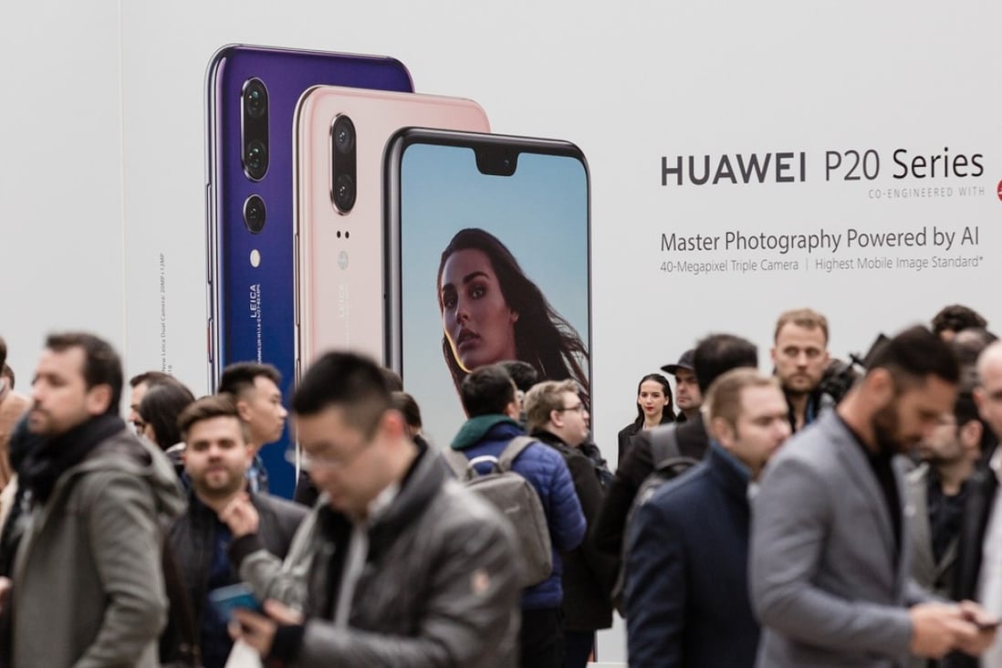 Attendees stand in front of Huawei Technologies Co. signage during the company's P20 Pro smartphone unveiling event in Paris, France, on Tuesday, March 27, 2018. Photo: Bloomberg