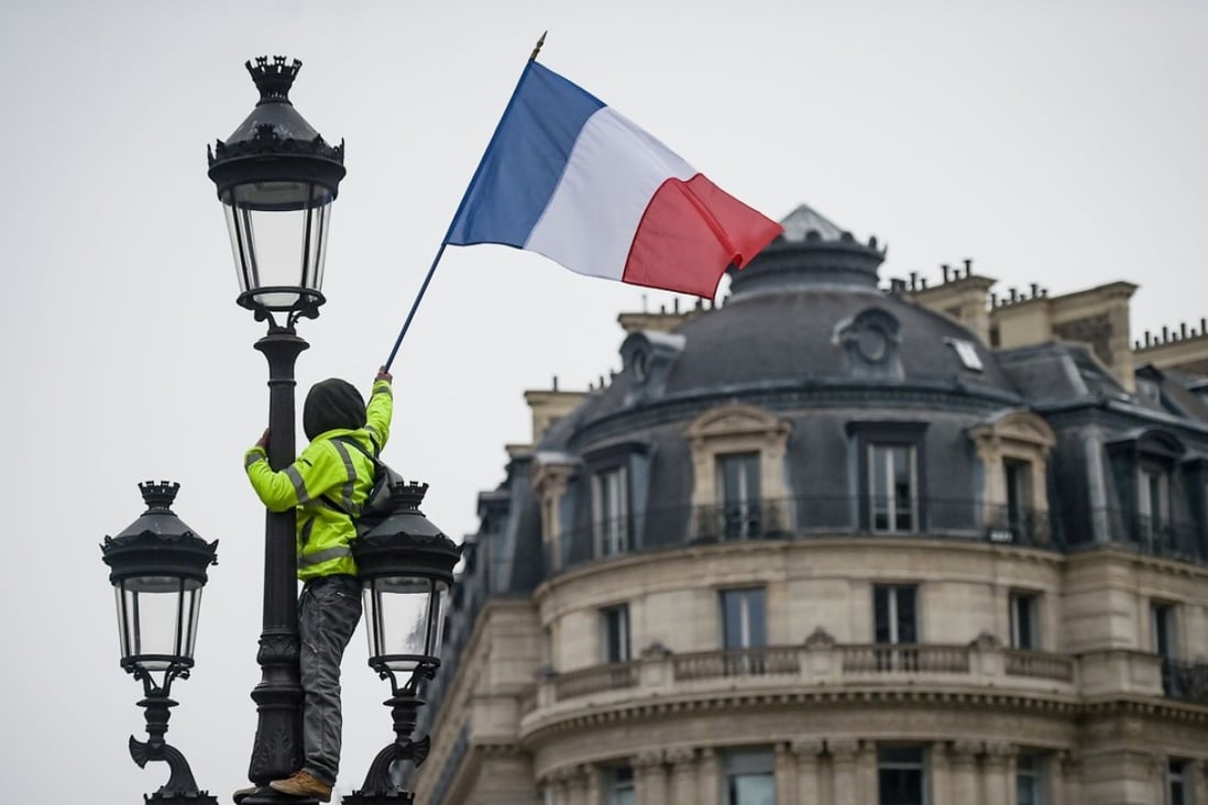 A protester wearing a yellow vest at the place de l'Opera in Paris The movement originally started as a protest about planned fuel hikes but has morphed into a mass protest against Macron’s policies. Photo: AFP