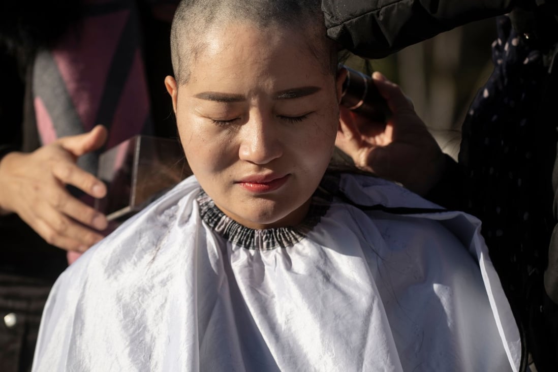 Li Wenzu has her head shaved to protest the detention of her husband, human rights lawyer Wang Quanzhang, in Beijing on Monday. Photo: AFP