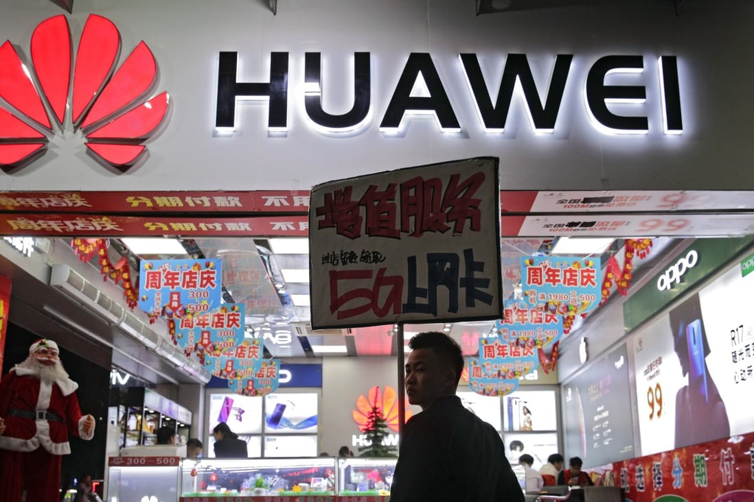 A worker holds a sign promoting a sale for Huawei’s 5G internet services at a mobile phone retail shop in Shenzhen in south China's Guangdong province, Tuesday, Dec 18, 2018. Photo: AP