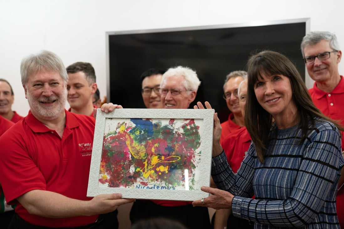 Co-founder Phyllis Marwah presents a painting by one of the children at the Child Care Home to the Hong Kong Male Welsh Choir during their visit. Photo: courtesy of Mother’s Choice