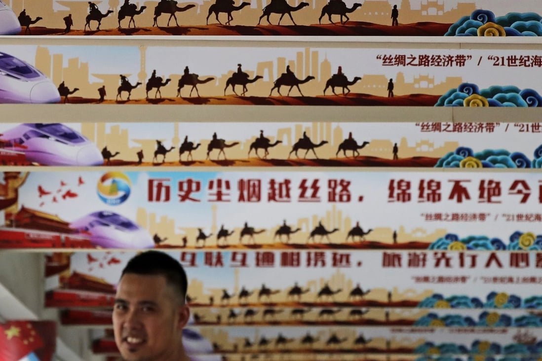 A man stands under signs promoting the “Chinese dream” and “Belt and Road Initiative” during an event in Beijing. The plan has come under increasing scrutiny. Photo: AP