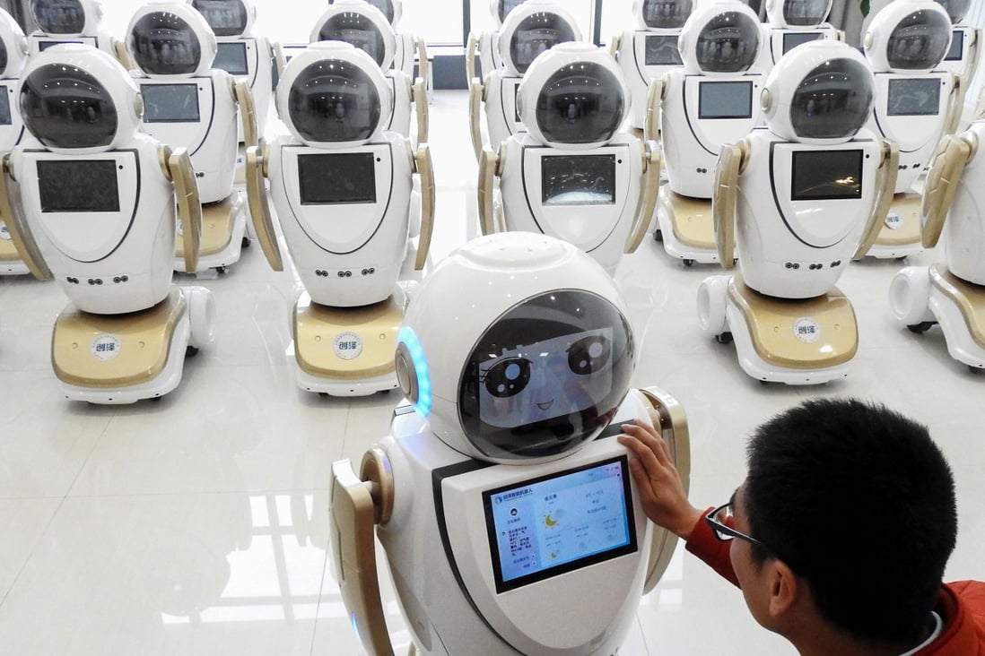 An employee checks robots used for customer service at a factory in eastern China. The draft law encourages tech cooperation based on voluntary principles and commercial rules. Photo: AFP