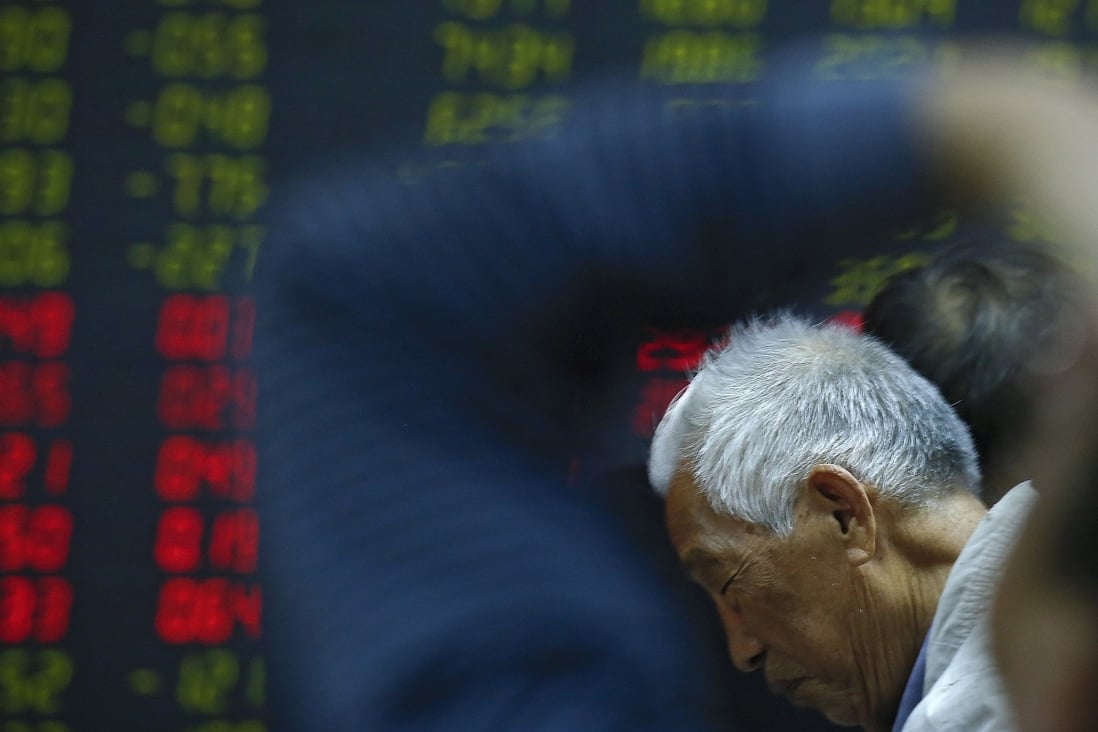 An investor reacts as he and investors monitor stock prices on October 24, 2018, at a brokerage house in Beijing. Photo: Associated Press