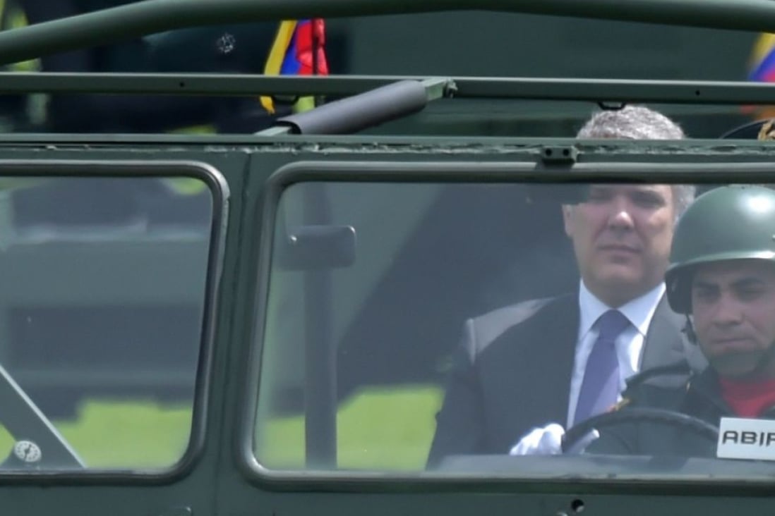 Colombian President Ivan Duque rides in a military vehicle at a ceremony in Bogota. Photo: AFP